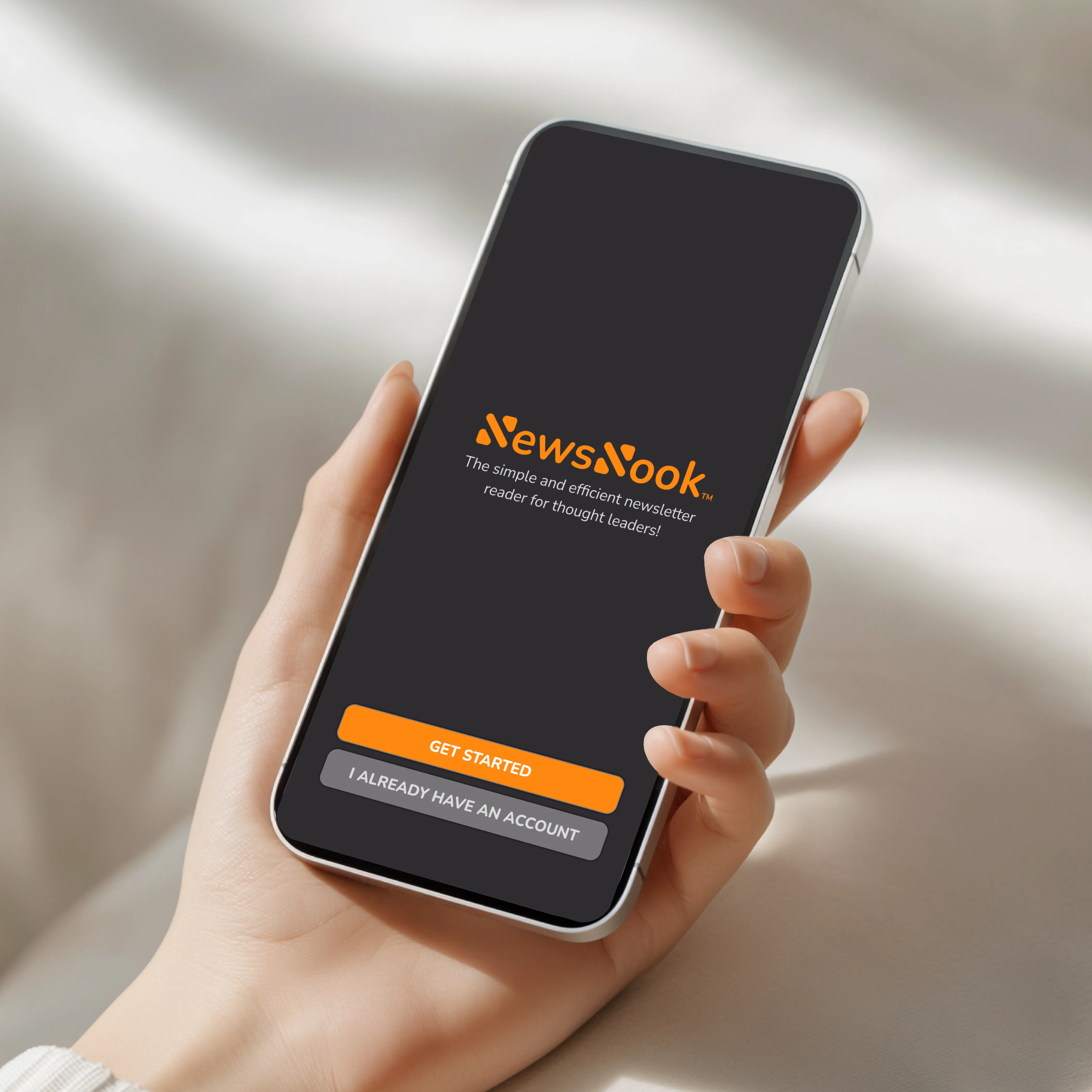 The NewsNook App shown on a phone held by a woman.